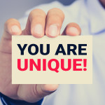 YOU ARE UNIQUE ! message on the card shown by a man hand, vintage tone