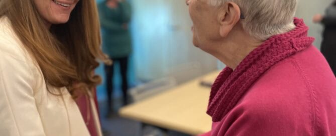 Business owners Jessica Rickert and Joyce Feustel talking at a networking event. LinkedIn training